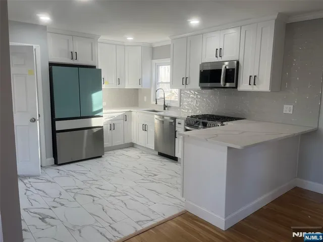 a kitchen with stainless steel appliances granite countertop a refrigerator sink and stove