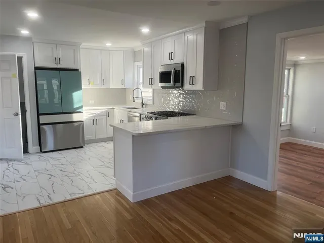 a kitchen with stainless steel appliances granite countertop a refrigerator and a stove top oven