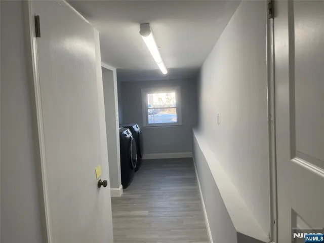 a view of a hallway with wooden floor and closet