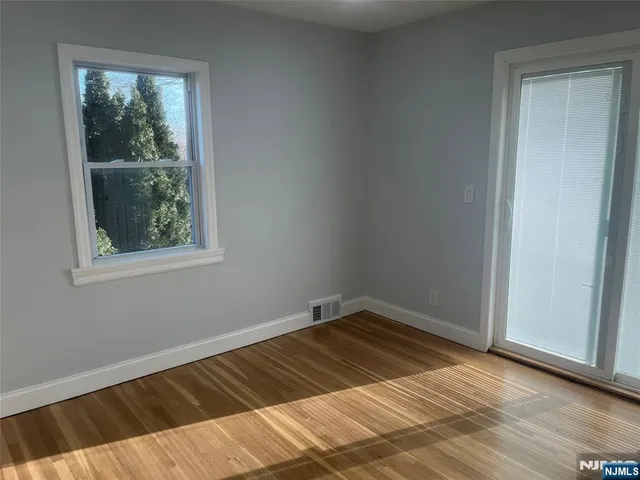 a view of a room with wooden floor and a window