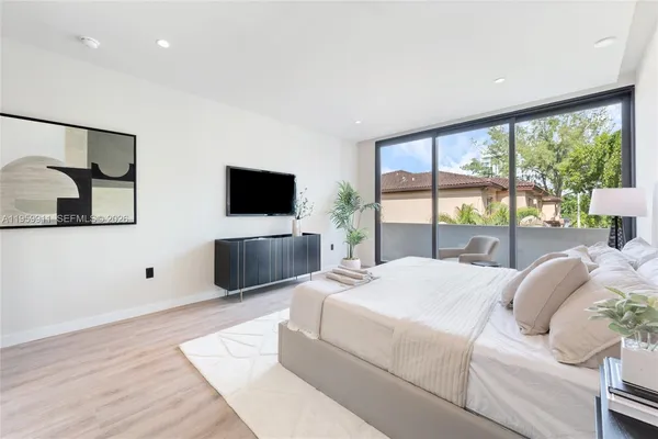 a living room with a large bed and a flat screen tv