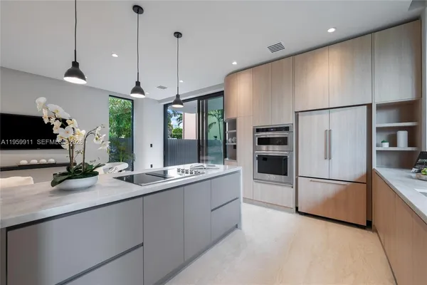 a kitchen with stainless steel appliances granite countertop a refrigerator a sink and a stove