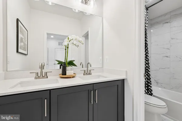 a bathroom with a granite countertop sink a toilet and a mirror