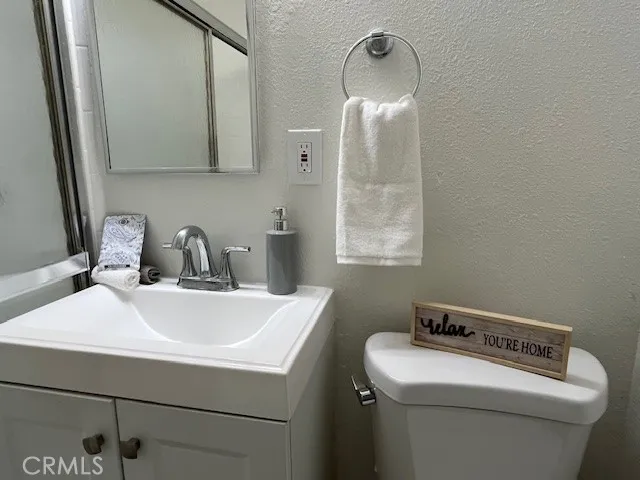 a bathroom with a sink a toilet and a mirror