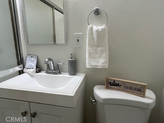 686 East Cottonwood Road, Unit 6 Palm Springs, CA 92262 - Photo 9 of 12 a bathroom with a sink a toilet and a mirror