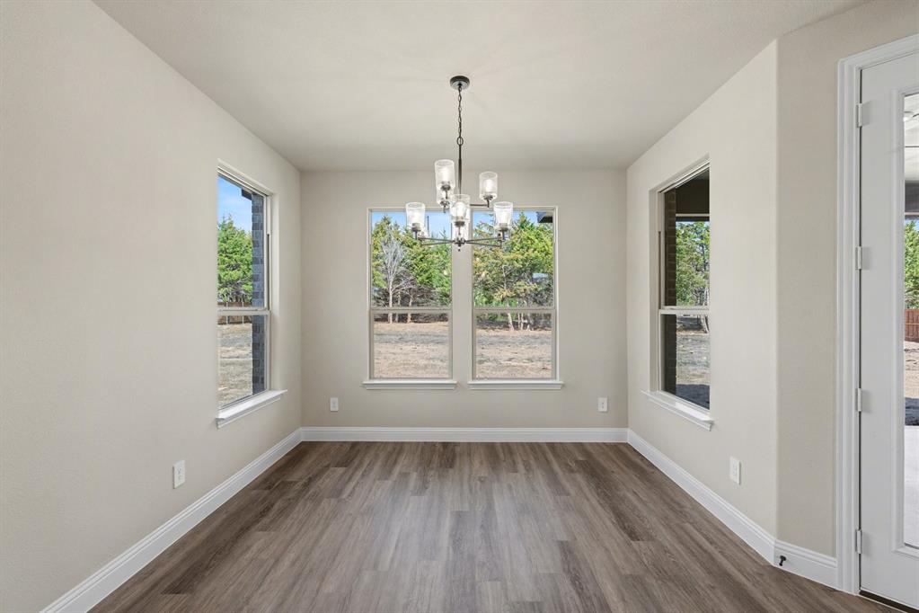 7041 Champion Road Midlothian, TX 76065 - Photo 8 of 30 a view of a room with wooden floors and chandelier