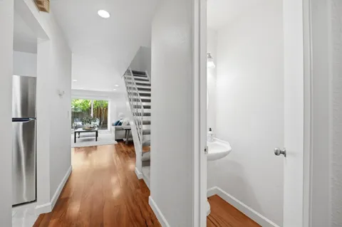 a view of a hallway with wooden floor and dining room