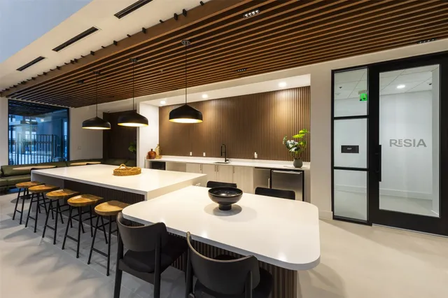 a kitchen with stainless steel appliances kitchen island a table and chairs