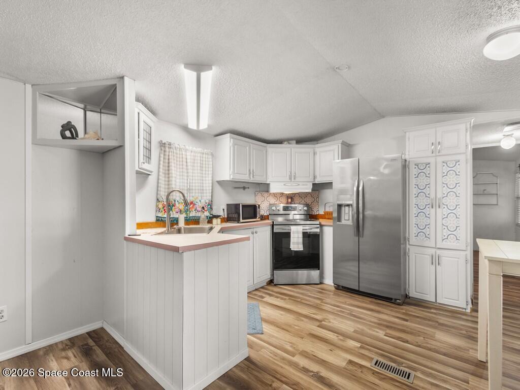 7380 129th Place Sebastian, FL 32958 - Photo 16 of 32 a kitchen with a refrigerator and a sink