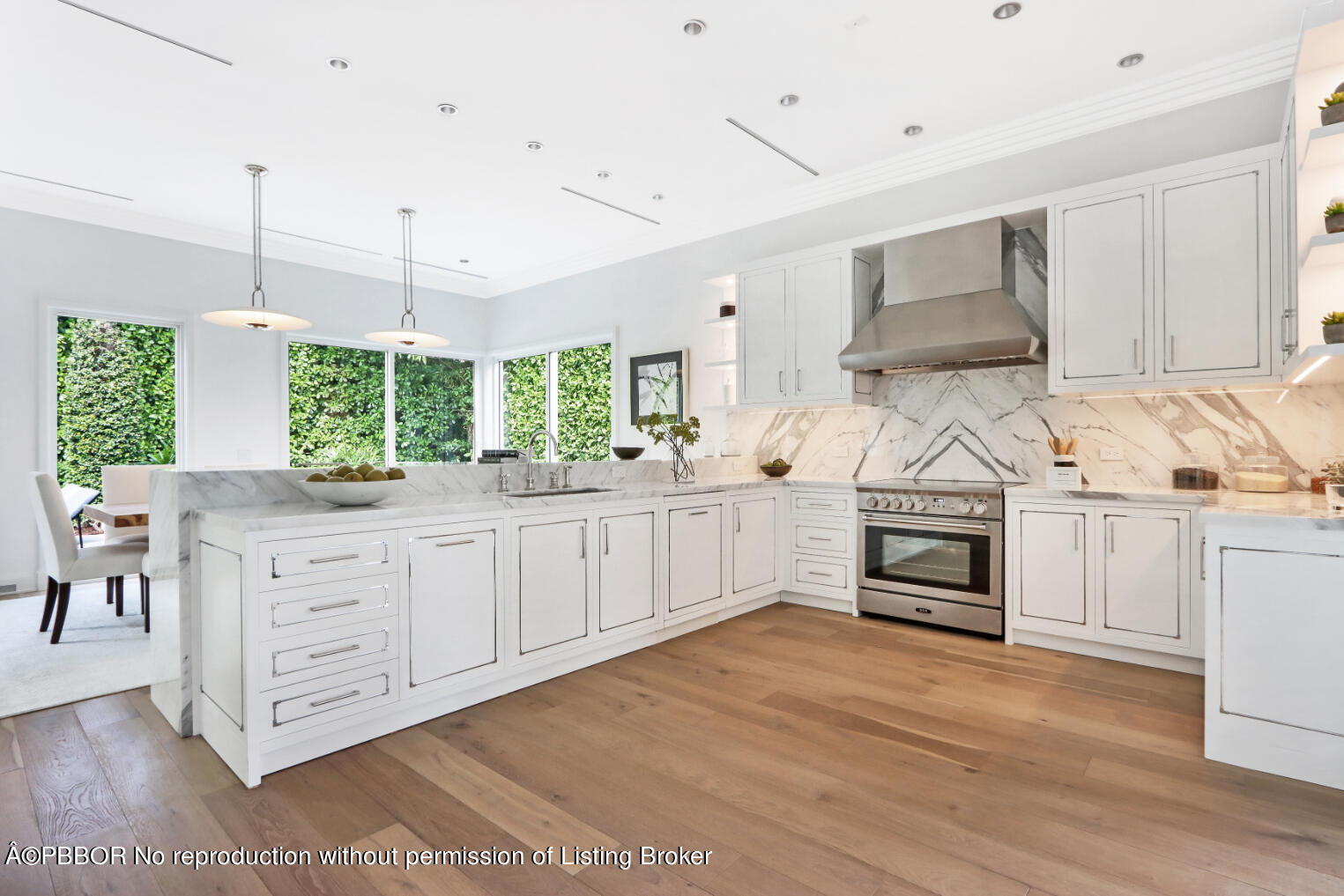 215 Indian Road Palm Beach, FL 33480 - Photo 7 of 31 a kitchen with stainless steel appliances kitchen island granite countertop a stove a sink and white cabinets with wooden floor