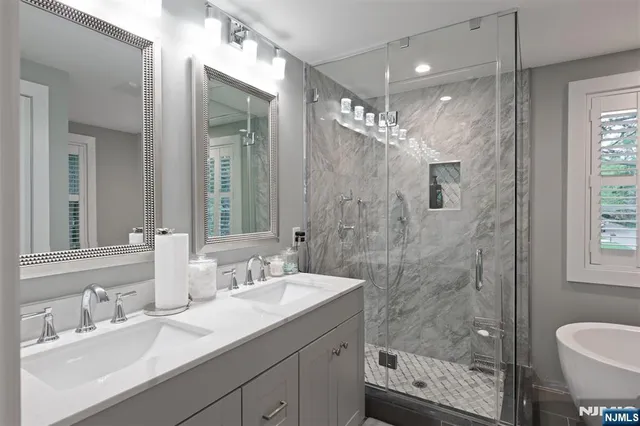 a bathroom with a shower sink double vanity and mirror