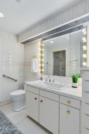 a bathroom with a double vanity sink toilet and a mirror