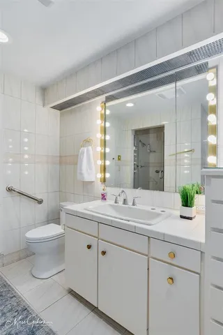 a bathroom with a double vanity sink toilet and a mirror