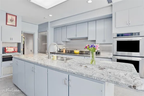 a kitchen with granite countertop a sink stainless steel appliances and cabinets