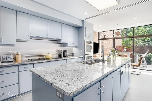 a kitchen with granite countertop sink and cabinets