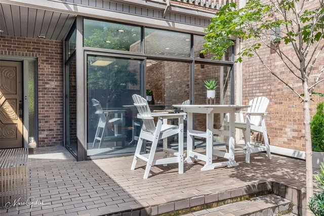 a view of a patio with a table chairs and wooden floor