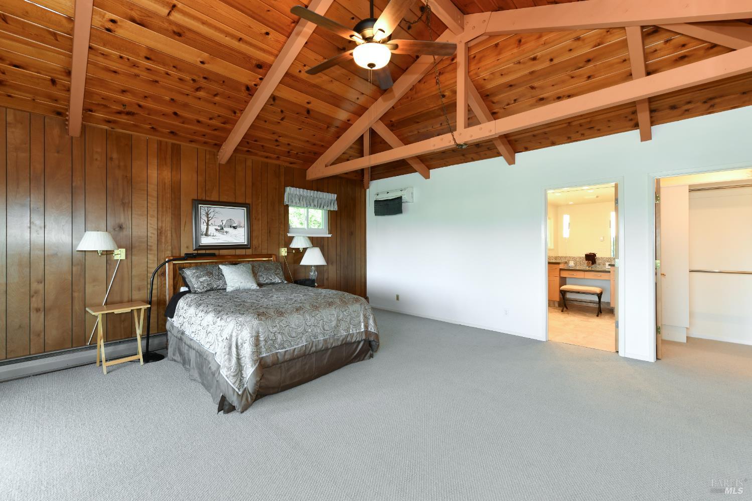 22 Monez Boulevard Napa, CA 94559 - Photo 15 of 30 a spacious bedroom with a bed and a chandelier