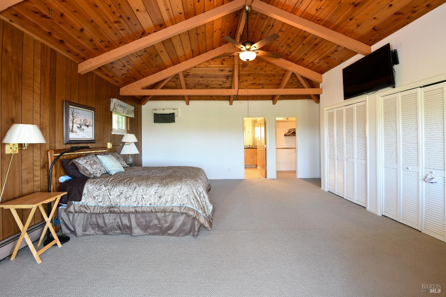 22 Monez Boulevard Napa, CA 94559 - Photo 16 of 30 a spacious bedroom with a bed and a chandelier