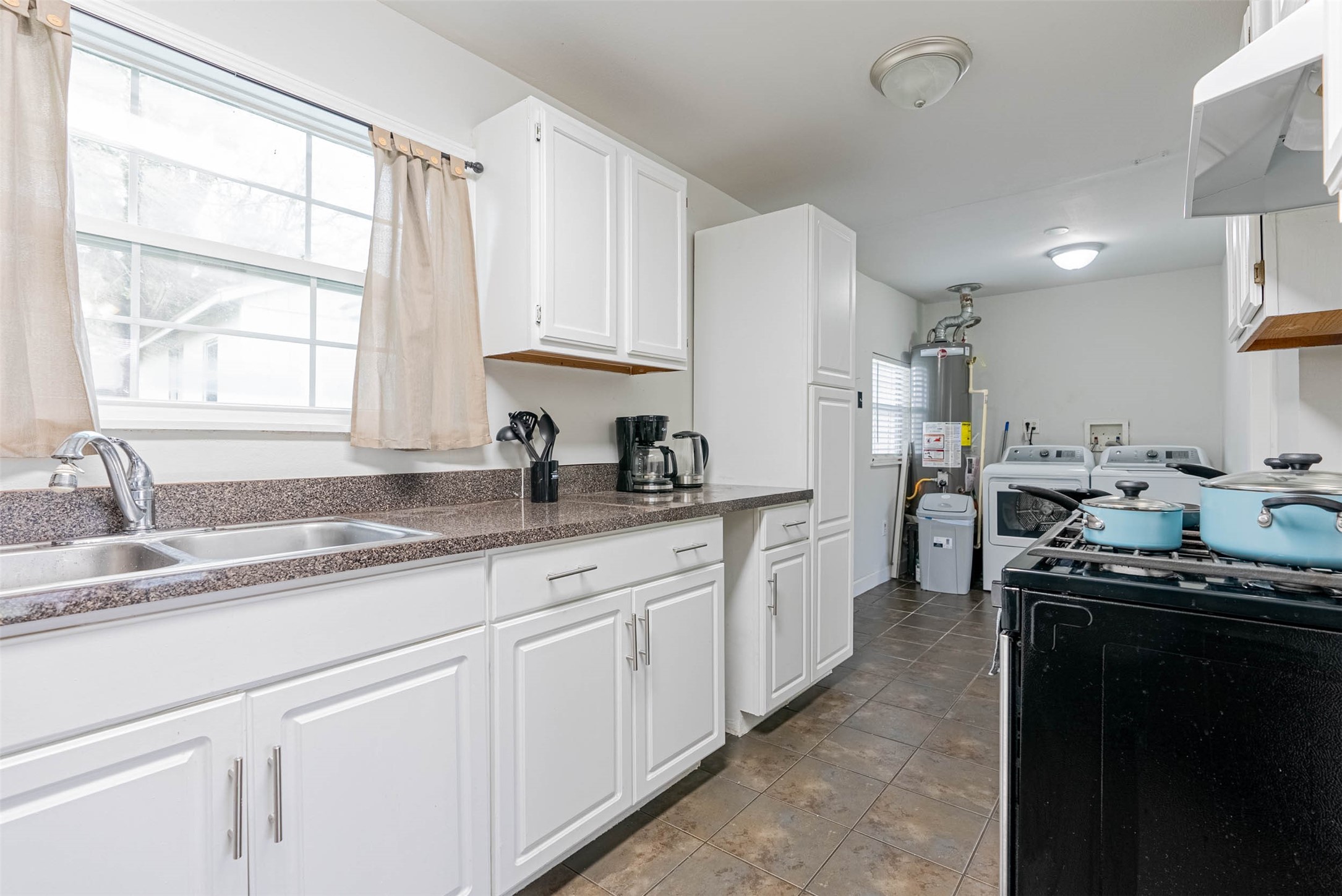 3910 Luca Street Houston, TX 77021 - Photo 16 of 29 a kitchen with granite countertop a sink stainless steel appliances white cabinets and a window