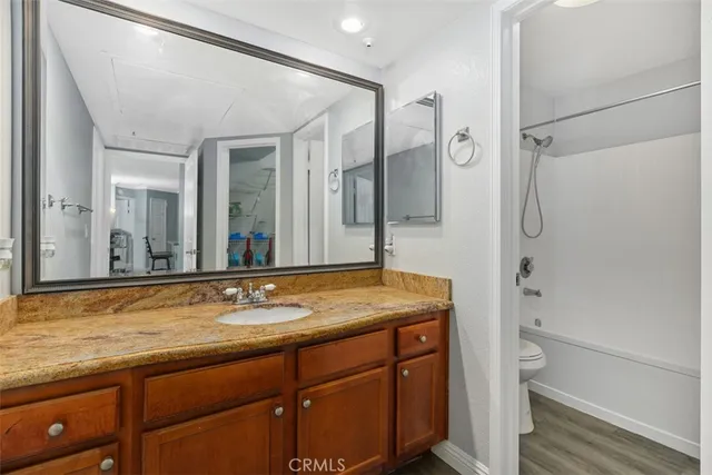 a bathroom with a granite countertop sink mirror and a shower