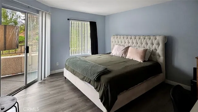 a bedroom with a bed lamp and a large window