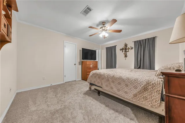 a bedroom with a large bed and ceiling fan