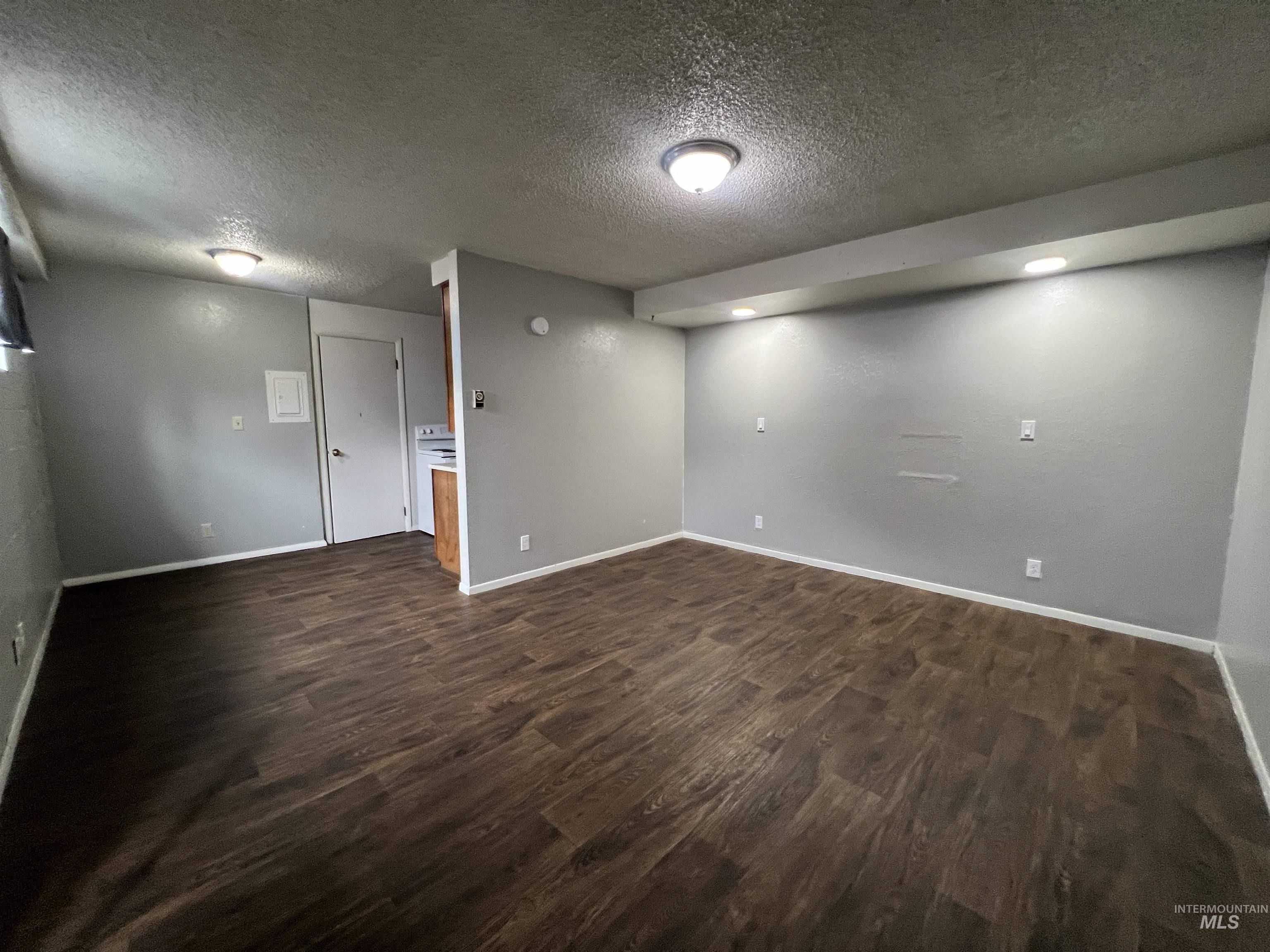 151 Northwest 8th Street Ontario, OR 97914 - Photo 21 of 30 Basement with dark wood-style flooring and a textured ceiling