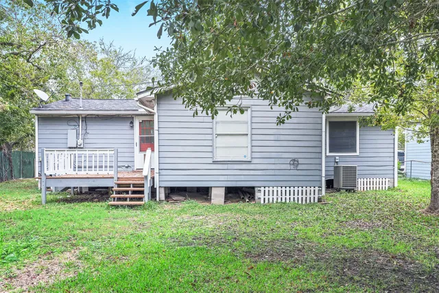 a view of a house with a backyard and a large tree