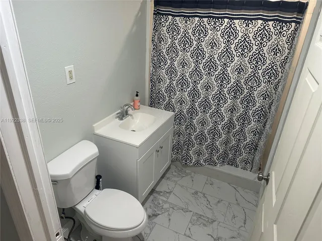 a white toilet sitting next to a shower curtain