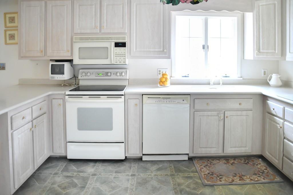 45 Powder Mill Road Sudbury, MA 01776 - Photo 5 of 20 a kitchen with white cabinets and white appliances