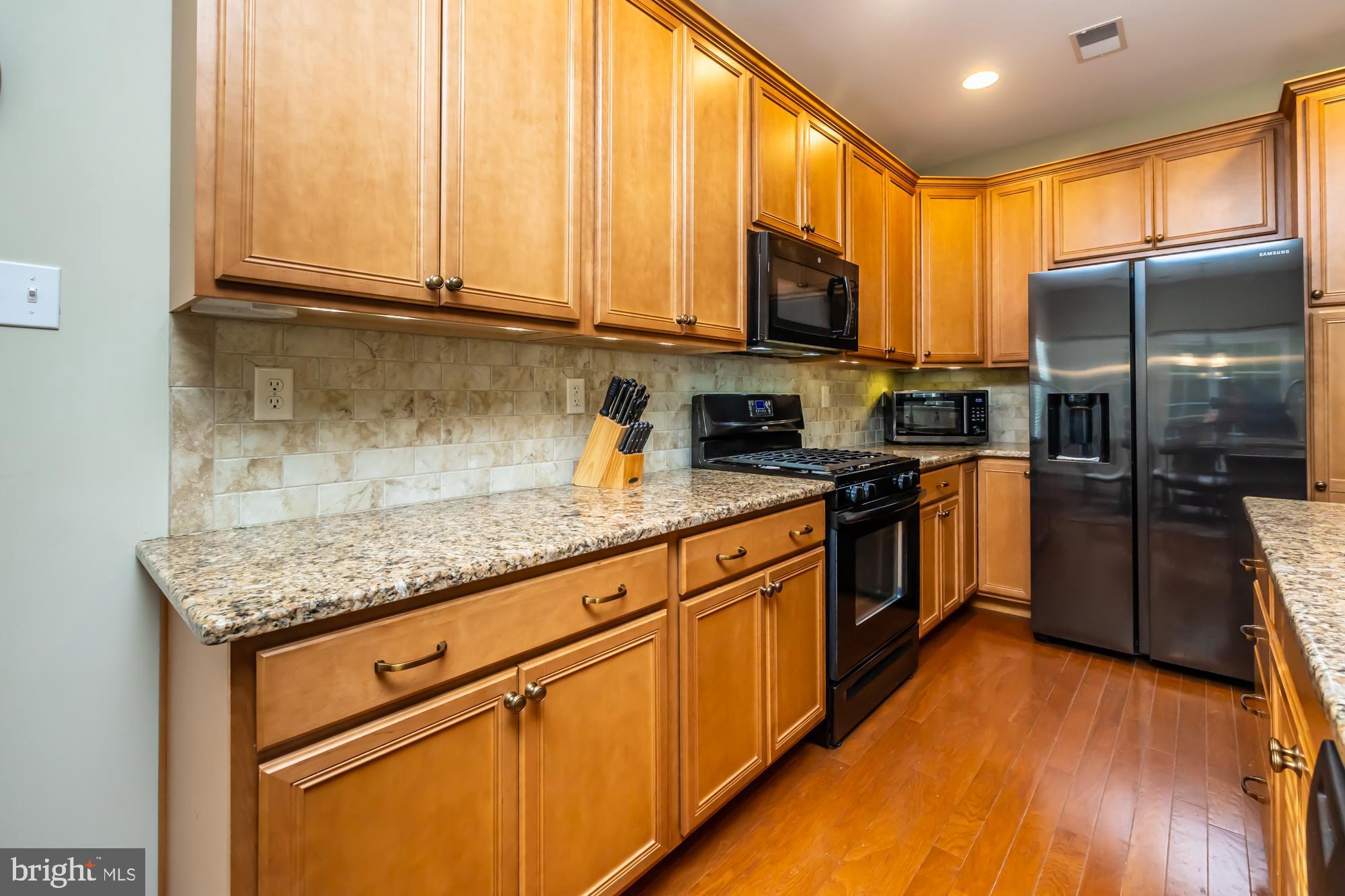 141 Stoyer Road Coatesville, PA 19320 - Photo 11 of 40 a kitchen with stainless steel appliances granite countertop wooden cabinets a refrigerator a stove a sink and dishwasher with wooden floor