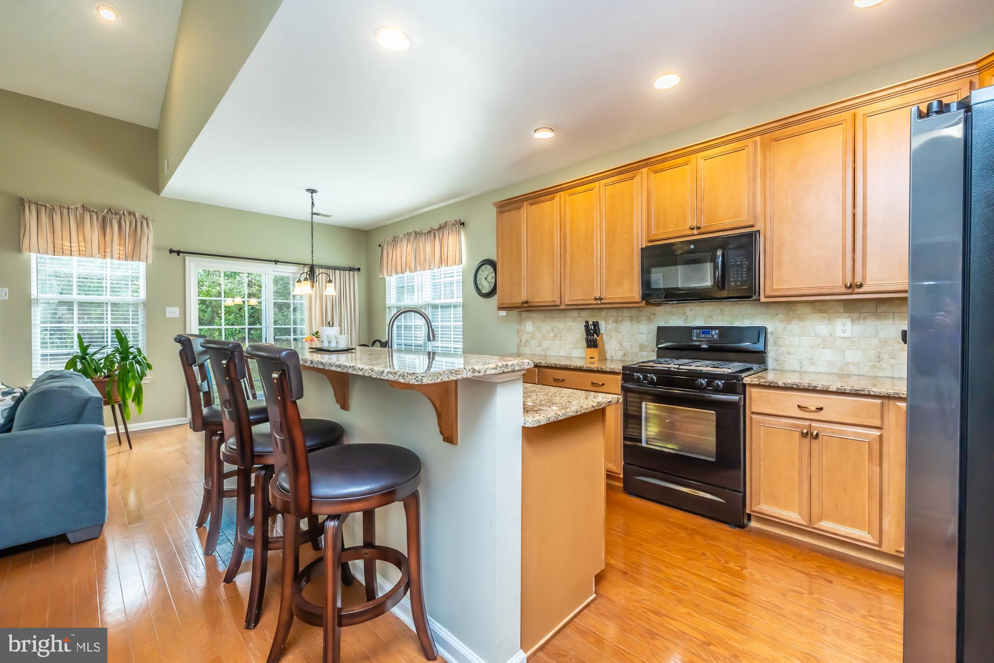 141 Stoyer Road Coatesville, PA 19320 - Photo 3 of 40 a kitchen with stainless steel appliances granite countertop a stove a sink a microwave a dining table and chairs