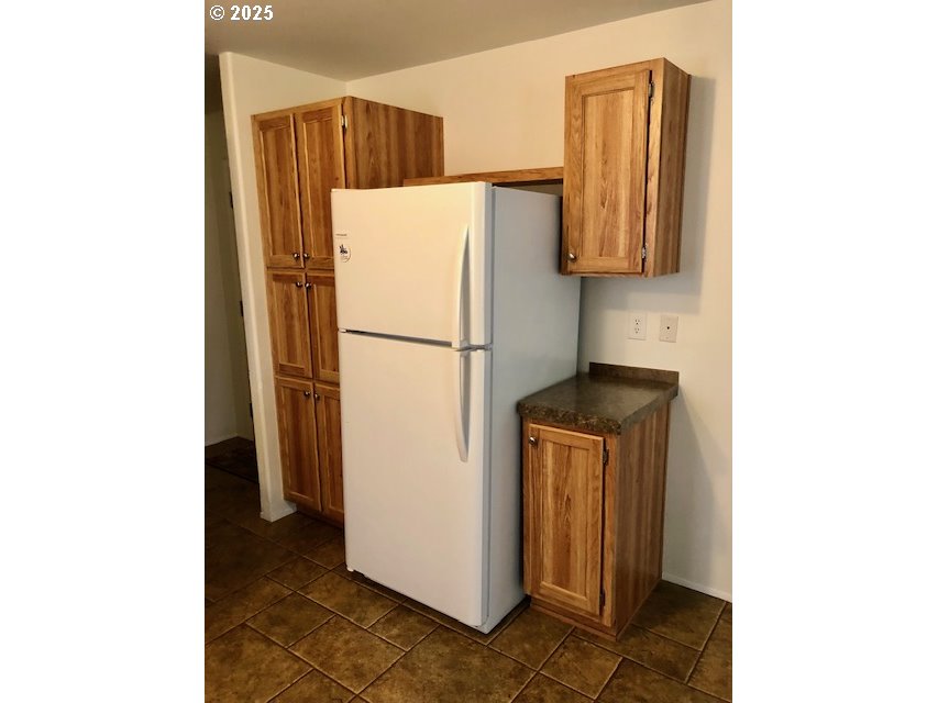 1475 Green Acres Road, Unit 76 Eugene, OR 97408 - Photo 8 of 23 a white refrigerator freezer and a stove sitting inside of a kitchen