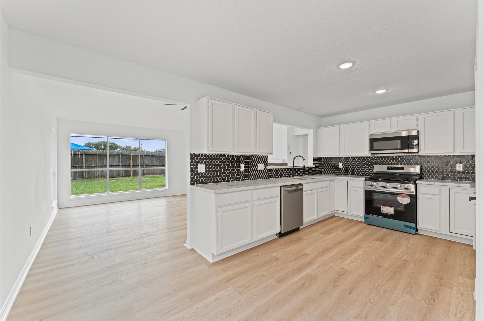17527 Hamilwood Drive Cypress, TX 77433 - Photo 11 of 32 a kitchen with granite countertop a stove top oven and cabinets