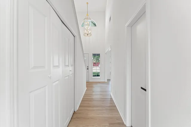 a view of a hallway with wooden floor and entryway