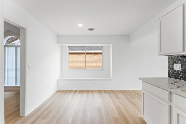 a view of a kitchen with wooden floor and electronic appliances