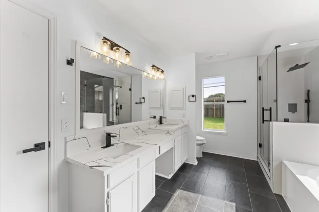 a large bathroom with a double vanity sink a mirror and a bathtub