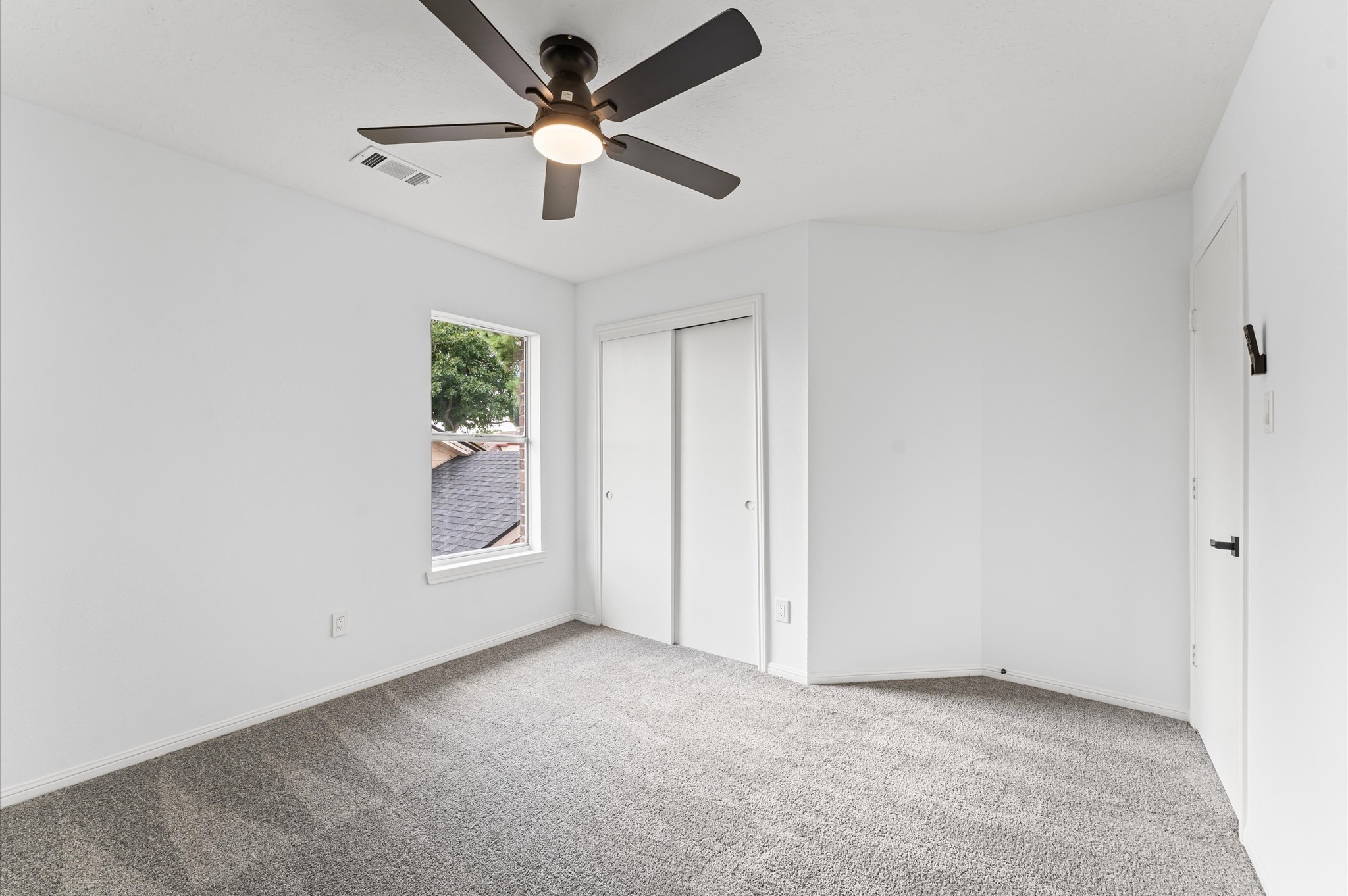 17527 Hamilwood Drive Cypress, TX 77433 - Photo 23 of 32 an empty room with chandelier fan and windows