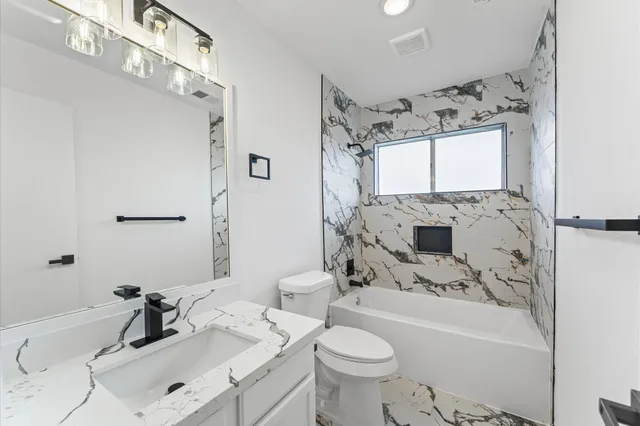 a bathroom with a sink toilet tub and shower
