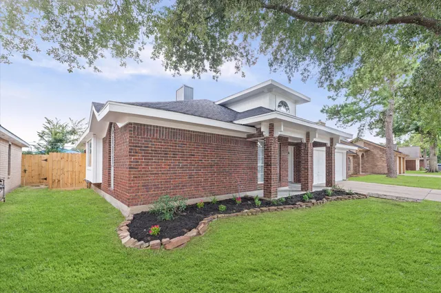 a front view of a house with a garden and yard