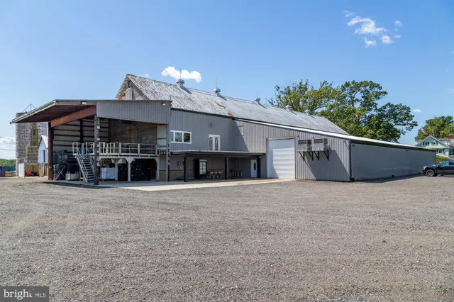 a view of a swimming pool and lounge chairs in back yard of the house