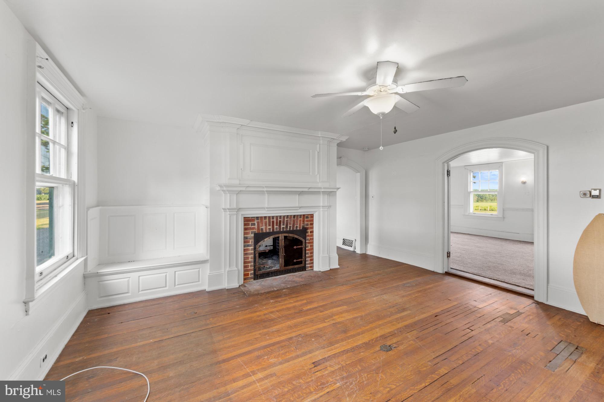 27058 Mt Pleasant Road Columbus, NJ 08022 - Photo 56 of 127 an empty room with windows fireplace and a kitchen view