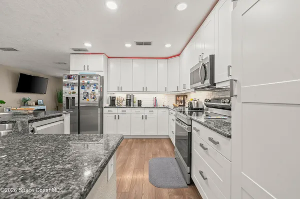 a kitchen with stainless steel appliances kitchen island granite countertop a refrigerator and a stove top oven