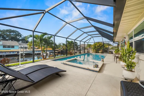 a view of a patio with a table and chairs under an umbrella