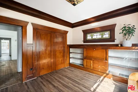 a view of a room with wooden floor and a flat screen tv