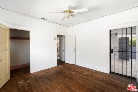 a view of a room with wooden floor and a ceiling fan