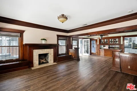 a view of an empty room with wooden floor and a fireplace