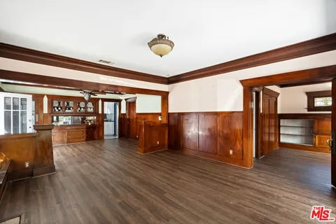 a view of an empty room with wooden floor and windows