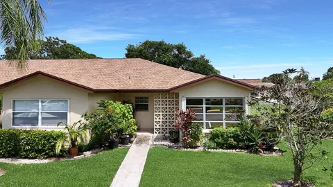 a view of a house with brick walls and a yard with plants