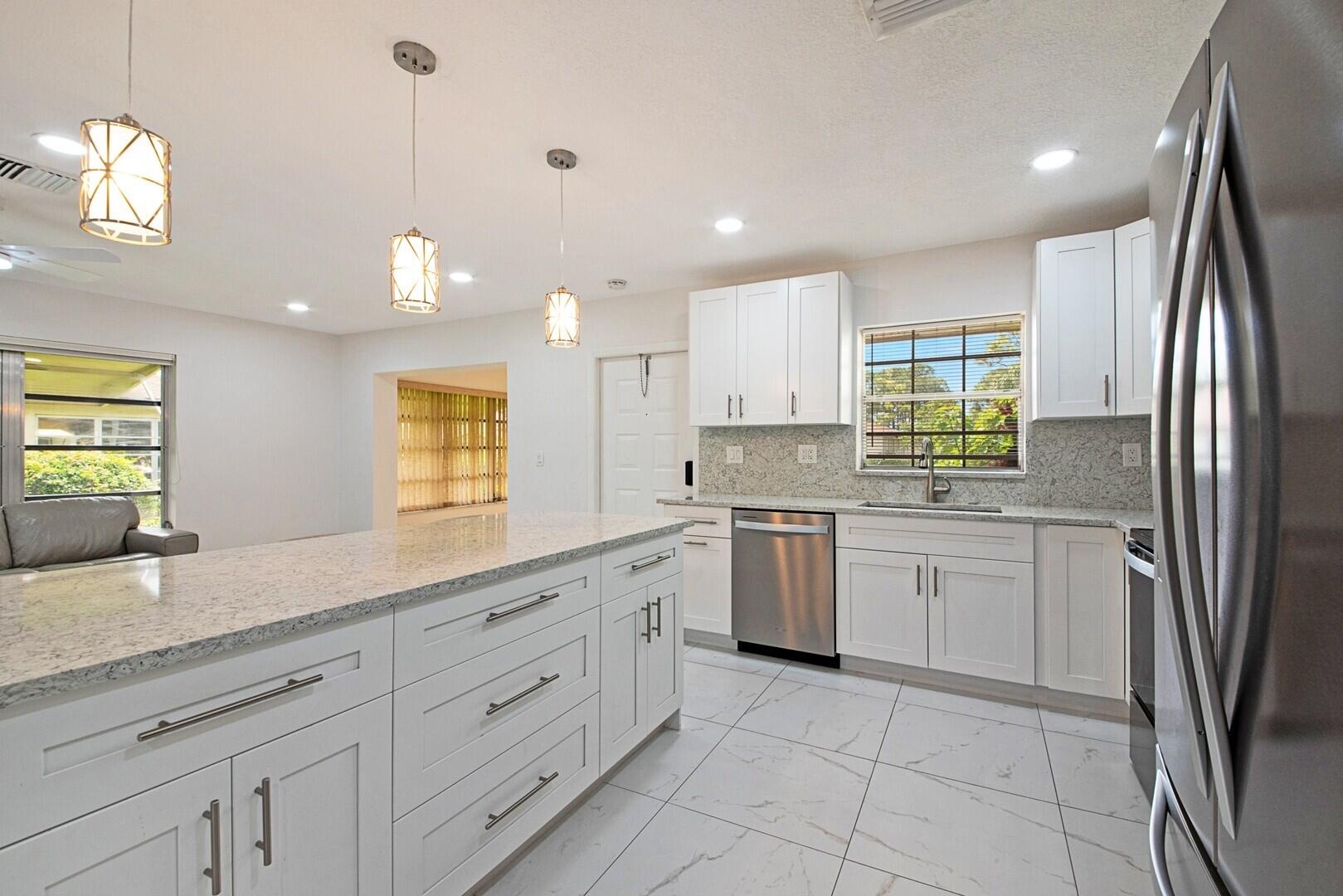 5220 Nesting Way, Unit D Delray Beach, FL 33484 - Photo 11 of 29 a kitchen with a sink window and refrigerator
